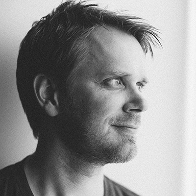 Black and white portrait of the photographer Philip Thomas looking out of frame